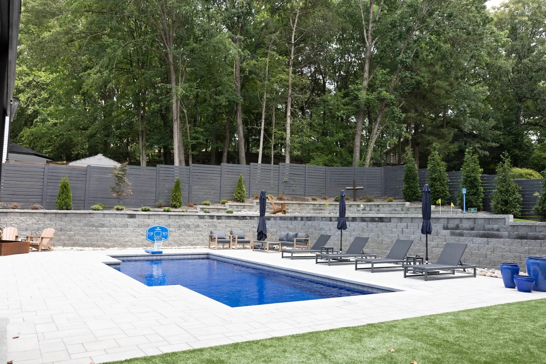 Rectangular pool, paver patio and horizontal privacy fence in a finished Charlotte, NC backyard