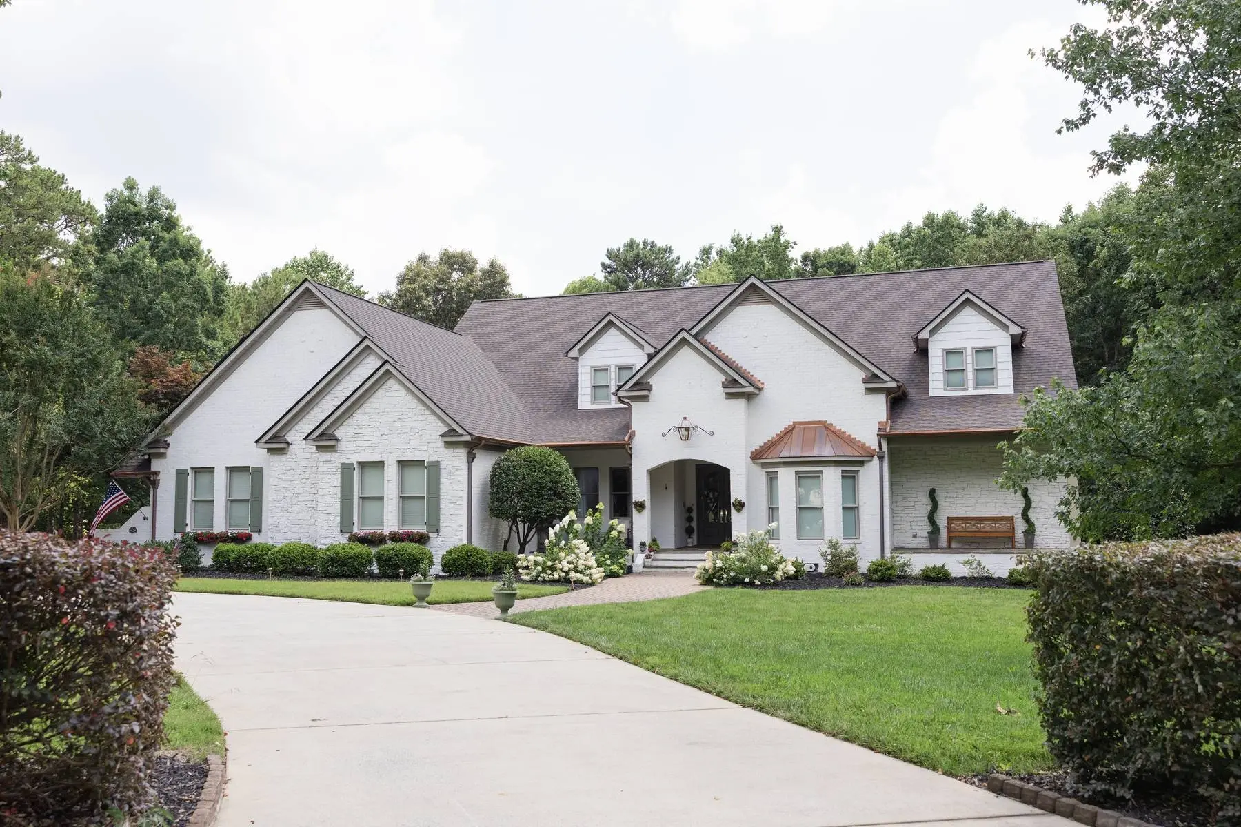 Front of a white brick home in Weddington, NC after a full copper gutter and downspout replacement
