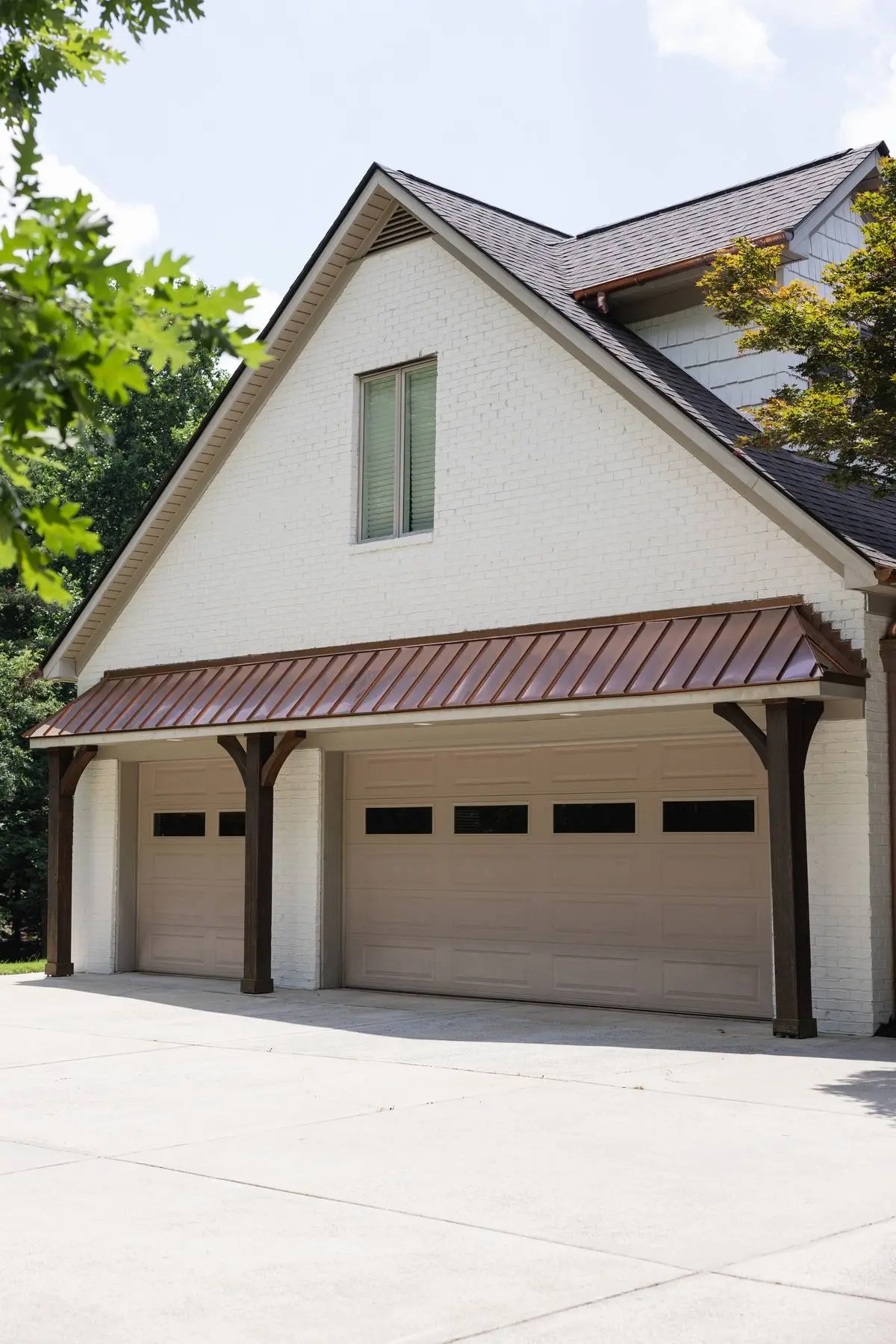 Three-car garage on a Weddington, NC home with a copper standing seam porch roof and copper gutters