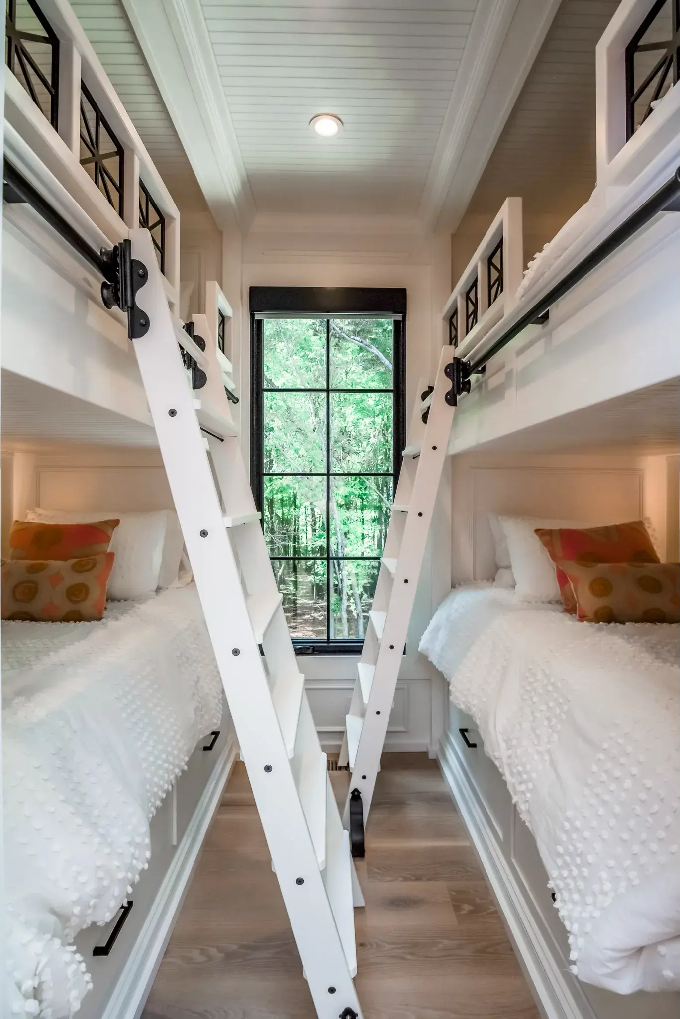 Bunk room with built-in beds on both walls, a rolling ladder and a shiplap ceiling