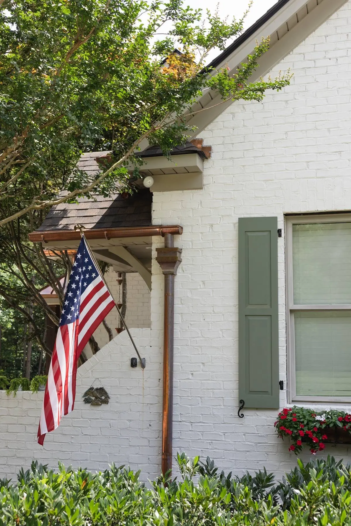 Copper gutter and downspout detail on a gable of a white brick home in Weddington, NC